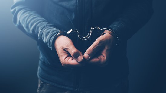 Arrested computer hacker and cyber criminal with handcuffs